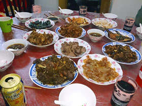 上海の家庭料理。旧暦の大晦日に一家揃って食べる年夜飯と呼ばれるもの。味は…手前のプレモルは持参。